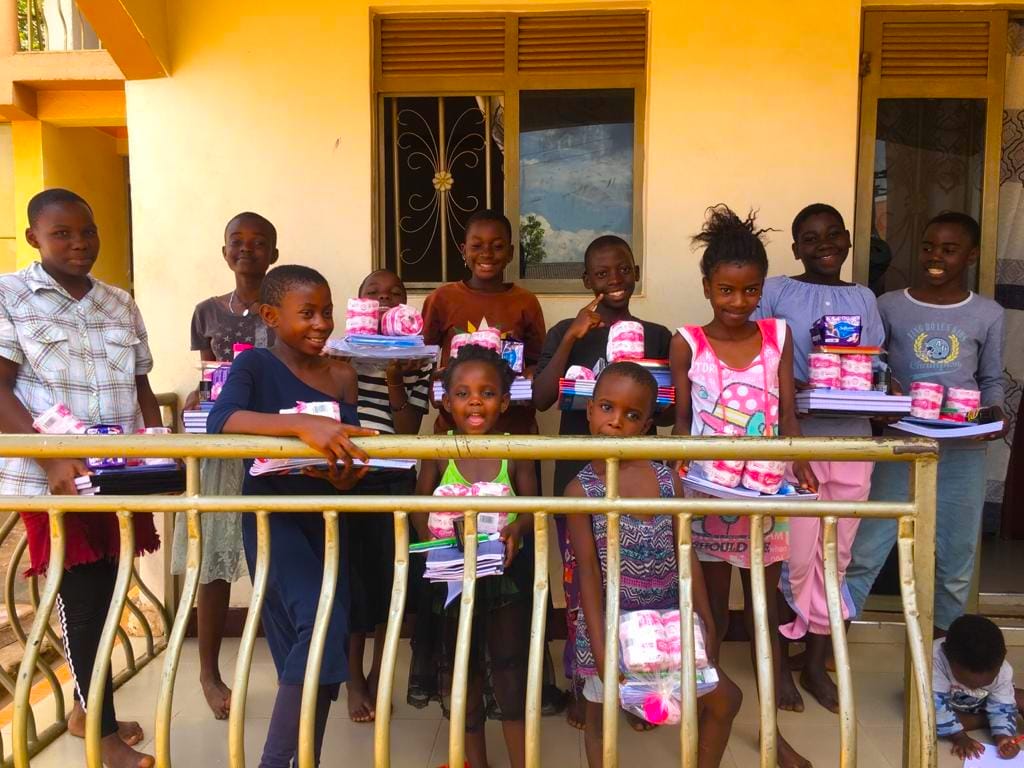 Desire children on a balcony holding new exercise books and supplies they have just been given